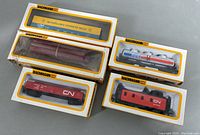 Five Bachmann HO miniature trains in original boxes, viewed from top, showing various box designs and contents.