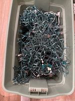 Bucket filled with many tangled Christmas light strands, clear bulbs and green wiring visible.