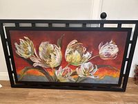 Full view of the large framed painting showing stylized white and yellow tulips on a red and orange background.