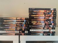 Stack of 22 James Bond movie DVDs lined up vertically and horizontally showing titles.