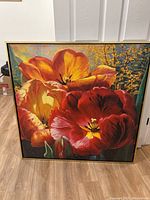 Full view of the large floral canvas painting showing vibrant red and orange tulips with green foliage and a gold frame.
