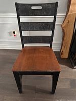 Front view of individual chair showing natural wood seat and three horizontal back slats on black frame.