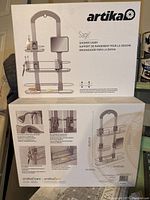 Closed retail box of Artika Sage shower caddy showing front with brand and product image.