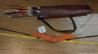Photo showing orange grip bow partially inserted with quiver and arrows