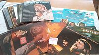 Photo showing a spread of 17 country music vinyl records including known artists such as Kenny Rogers, Jerry Reed, Don Denver, and Willie Nelson with Waylon Jennings.