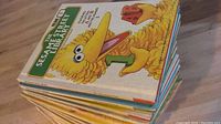 Photo of a stack of Sesame Street Library books with Big Bird prominently on the top cover, showing the condition and size of the set.