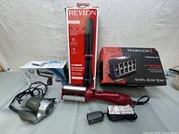 Overview photo showing all three items: Conair hair dryer, Revlon heated hair brush, and Remington Thermaluxe hair setter kit in box.