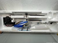 Remote control Heli-Raider helicopter in original molded foam packaging, blue canopy with logo, remote control included.
