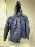 Front view of blue Minus Zero jacket with hood and flap pockets