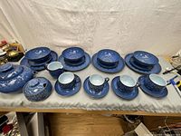 Entire 25 piece set including teapot, sugar bowl, cream jug, cups with saucers, bowls, and plates arranged on a table.