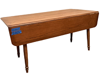 Full view of the oak drop leaf table with leaves down, showing turned legs and wood grain.