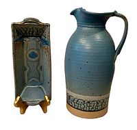 Blue pottery pitcher and matching rectangular dish on display stand.