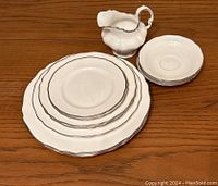 Top view of the full set showing the plates, saucers, and creamer with platinum trim.