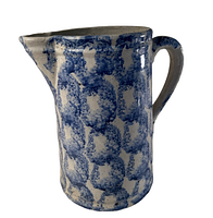Side view of vintage ceramic pitcher showing blue pattern and handle