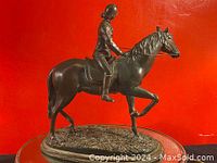 Front-side view of equestrian bronze sculpture showing rider and horse details
