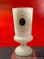 Full view of the 12-inch tall frosted opaline vase standing against a red background, showing overall shape and the cameo medallion on the front.
