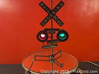 Front view of the railroad crossing sign with illuminated red and green signal lights and directional signage.