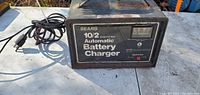 Front view of black Sears Automatic Battery Charger showing brand name, model number 10/2, ammeter, and selector switch.