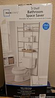 Photo of the box showing the product name, brand, and image of the 3-shelf bathroom space saver rack over a toilet.