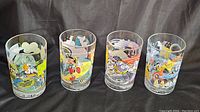 Full set of four Disney collectible glasses with colorful character prints celebrating 100 Years of Magic.