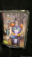 Box packaging showing image and details of the Huntington Home 4 Foot Inflatable Cat self-inflating Halloween decoration.