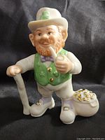 Front view of Lenox Lucky Leprechaun porcelain figure showing detailed face, clothes, and pot of gold on the floor.