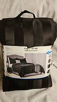 Photo showing packaged Mainstays king size comforter set with label and handle, packed neatly.