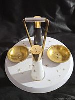 Top view of salt and pepper shakers on metal tray with starburst design and carrying handle.
