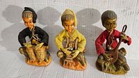 Set of three Mid Century Pixie Elf figurines sitting and playing musical instruments, showing all three together
