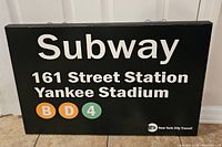 Front view of the rectangular wallhanger sign showing Subway 161 Street Station Yankee Stadium with B, D, and 4 subway line logos on black background.