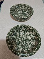 Two stacked green spongeware bowls showing external and internal sponge pattern.