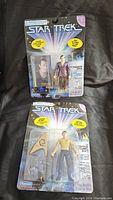 Two vintage Star Trek action figures in original packaging, mounted on colorful Star Trek-themed cards