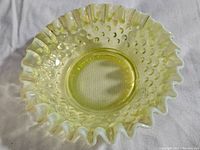 Top-down view of the yellow Vaseline glass dish showing hobnail pattern and ruffled rim.