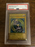 Front view of 2002 Yu-Gi-Oh! Dark Magician card graded PSA 5 in protective slab, showing character art and stats.