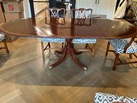 Full view of table fully extended with both leaves in place on wood floor