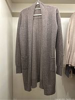 Full front view of the taupe cashmere cardigan hanging, showing length and open front style.