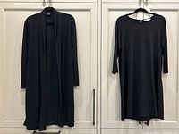 Two black women's clothing items hung on white cupboards for clear view: Max Mara cardigan and Michael Kors dress, both size large and jersey knit fabric