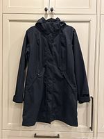 Full front view of the black Patagonia hooded winter coat hanging against a light-colored backdrop. Shows coat length, hood, front pockets, and closure details.