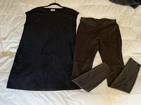Photo of the black sleeveless ultra suede tunic with two front patch pockets and the loden green ultra suede tights laid flat on a light-colored surface.