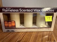 Front view of boxed set of three flameless scented wax candles with vanilla fragrance, packaging shows candles and product details.