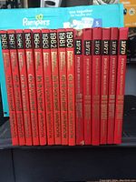 Spines of 14 DIY Yearbook books from 1974 to 1988 and 6 Popular Mechanics volumes from 1967 to 1979 arranged upright, showing titles and years.