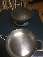 Top view of cast iron Christmas pot with lid and stainless steel pan showing overall condition and handles