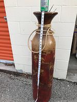 Full view of tall ceramic vase with measuring tape showing height approximately 45 inches.