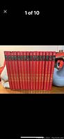 Set of 17 red hardcover Popular Mechanics Do-It-Yourself Encyclopedia books lined up on a shelf showing spines