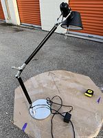 Full view of adjustable black and chrome desk lamp on round table