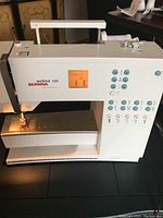 Front and side view of Bernina Activa 130 sewing machine on table