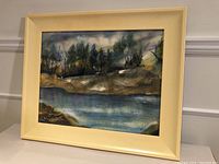 Framed watercolour landscape titled 'Approaching Storm' by Joan Foerter shown straight on with visible muted cream frame.