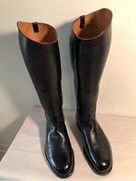 Pair of tall black leather riding boots shown from top view, standing upright showing the rounded toe and smooth polished leather surface.