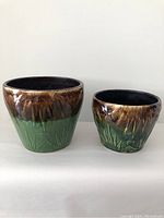 Two vintage Roseville pottery pots side by side on a white background showing overall size and glaze colors.