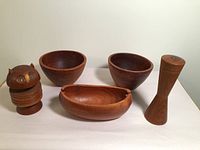 Full view of teak owl coaster, three teak bowls, and Danish teak pepper mill showing overall lot contents and condition
